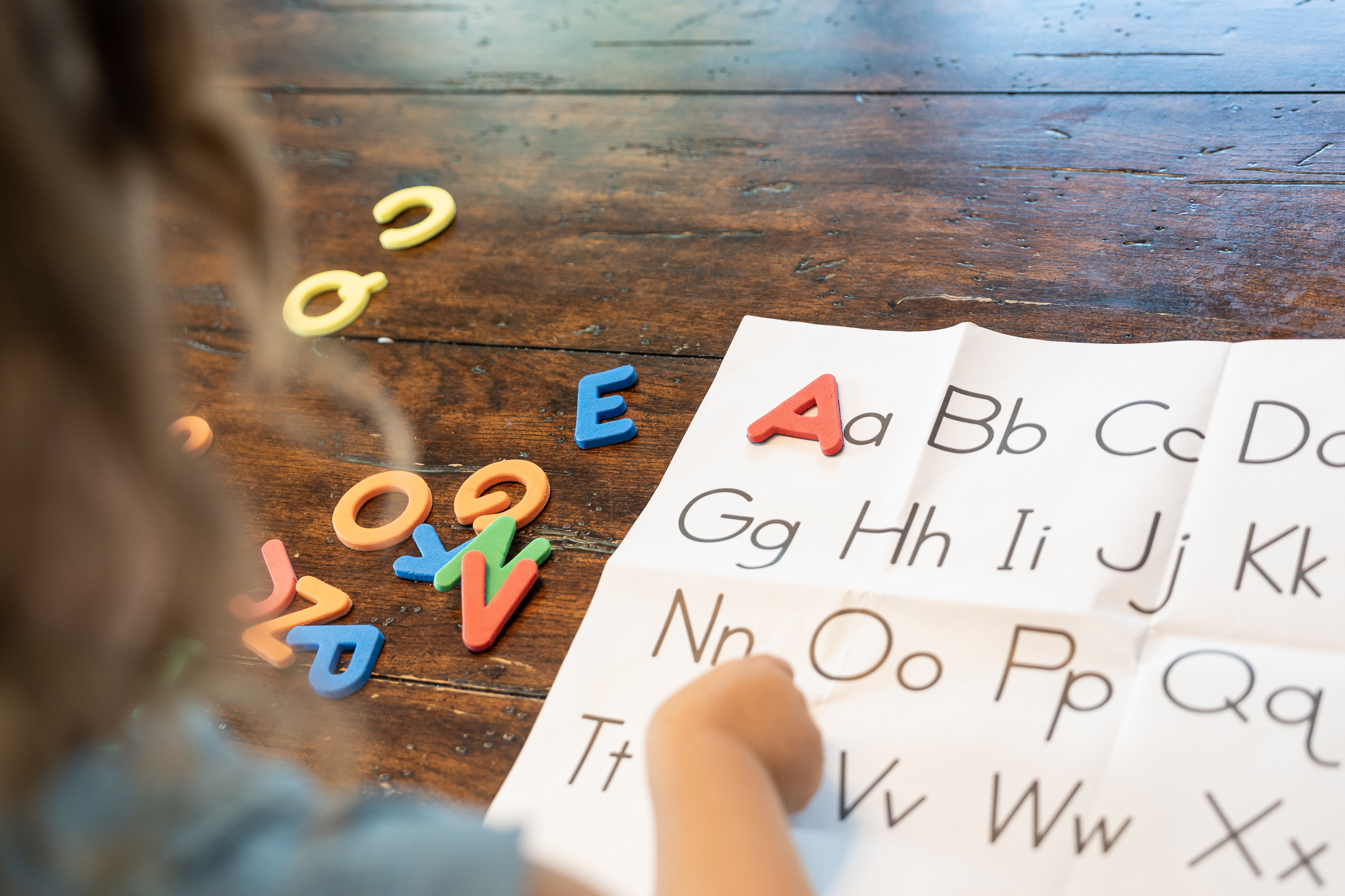 child looking at letters on a sheet of paper