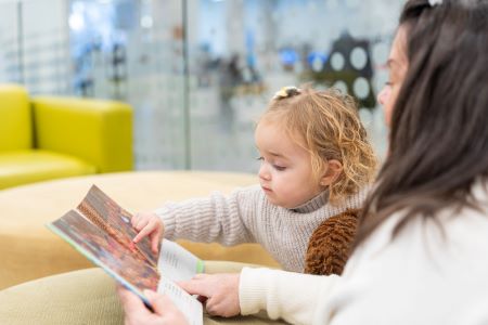 woman reading a book to a child